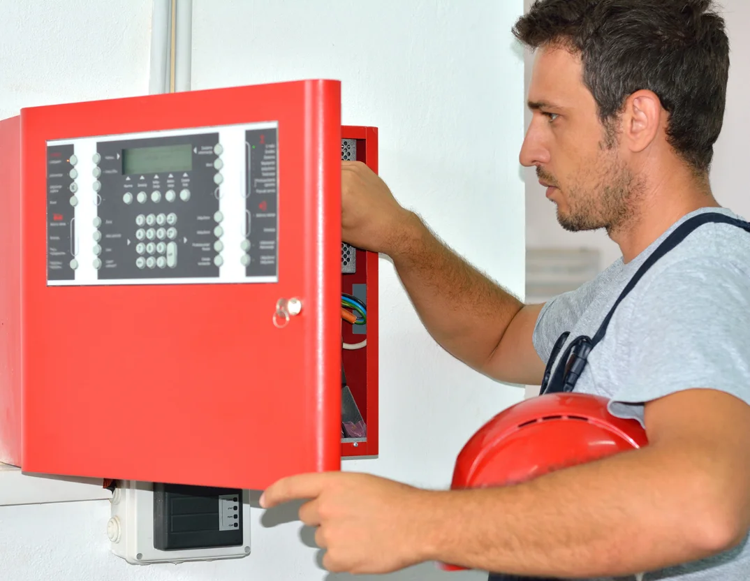 Technician carrying out an annual fire alarm inspection