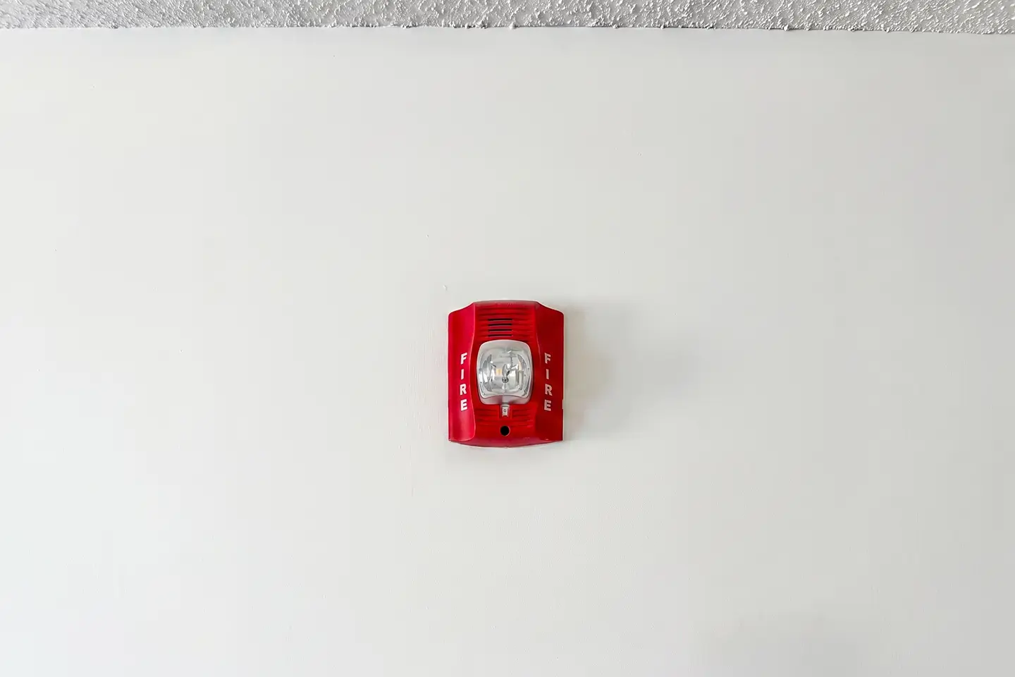 Fire alarm horn strobe mounted on a commercial building wall